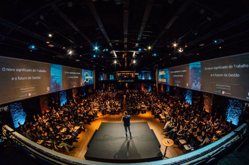 A speaker on stage addressing a full conference hall